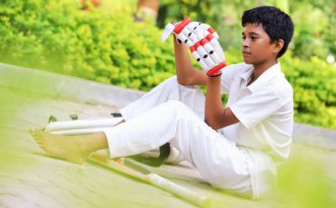This Young Boy from India is Motivated to Perform Well to Earn his Place Supporting his Favorite Cricket Team.  He is dressed in his Team Uniform and Ready for Action!